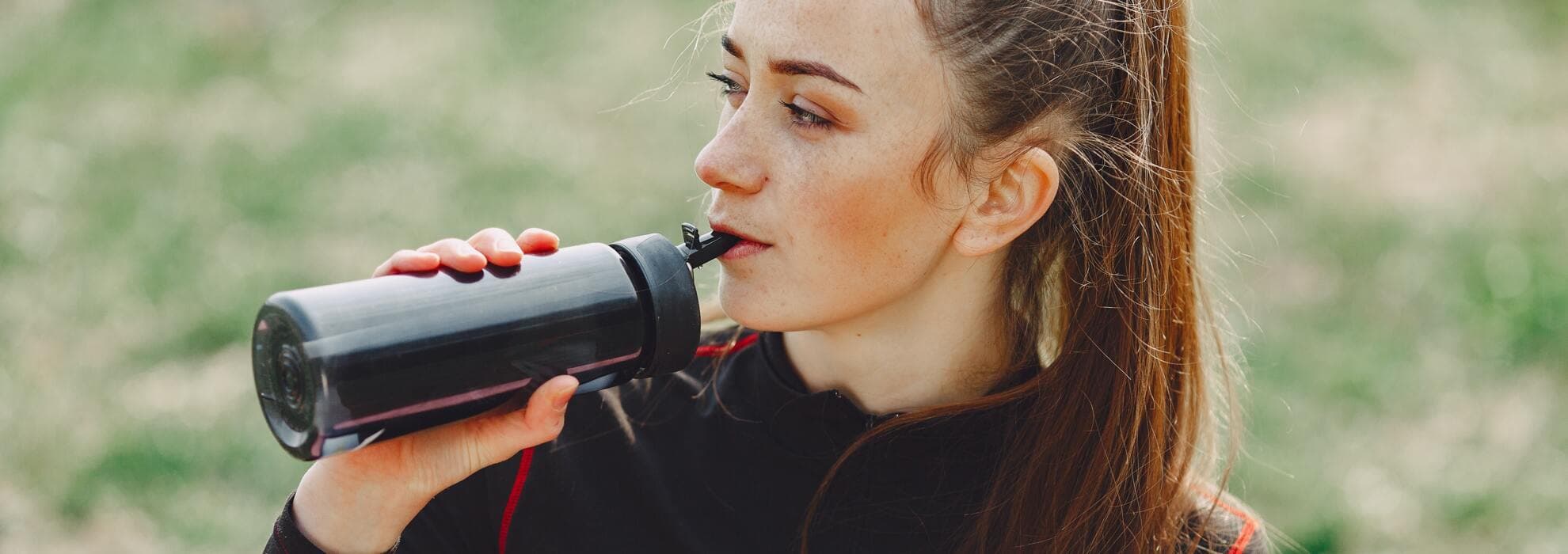 Kvinna som dricker ur vattenflaska