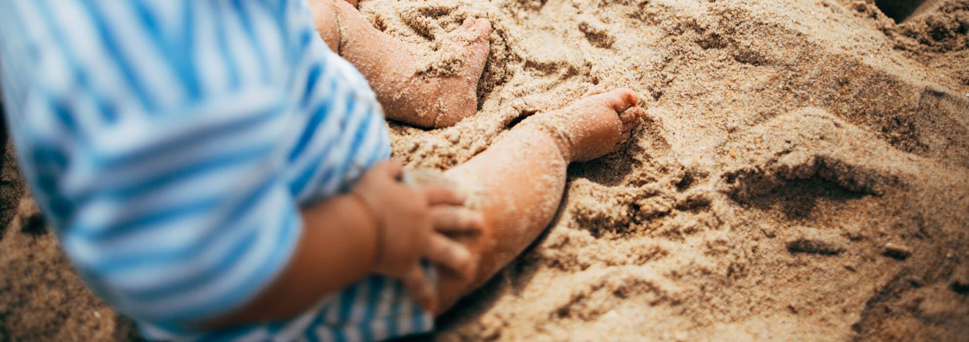 barn sitter pÄ strand