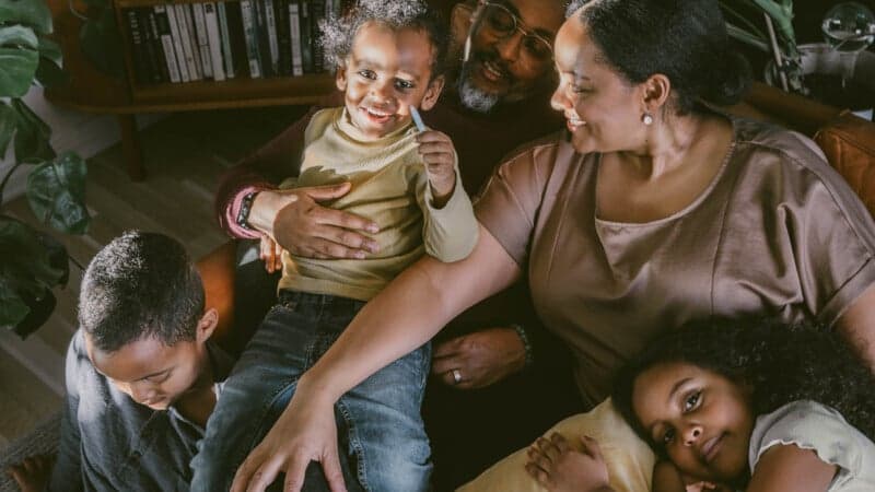 Familj som sitter i soffa Familj som sitter i soffa