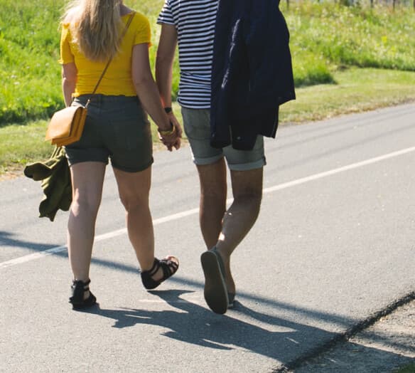 Promenerande par håller varandra i handen