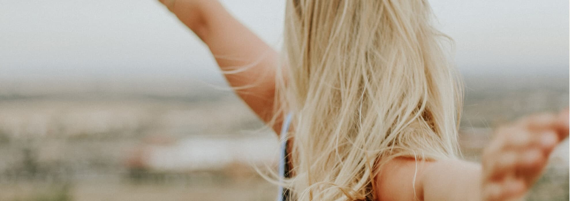 Kvinna sträcker upp händerna i luften