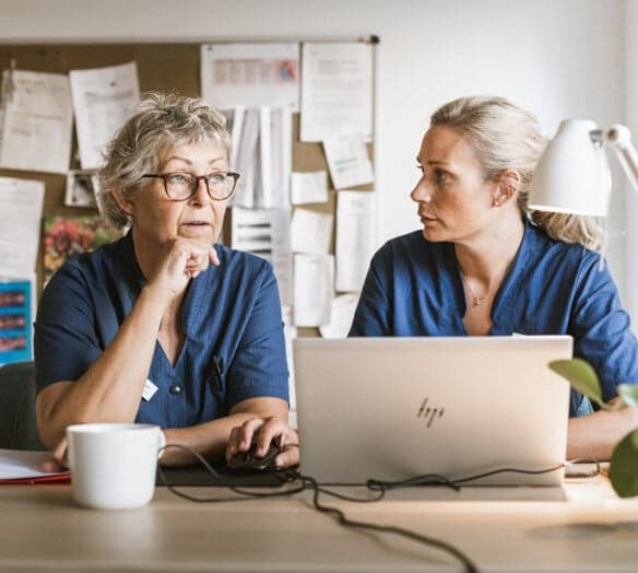 Personal sitter och pratar framför laptop Personal sitter och pratar framför laptop