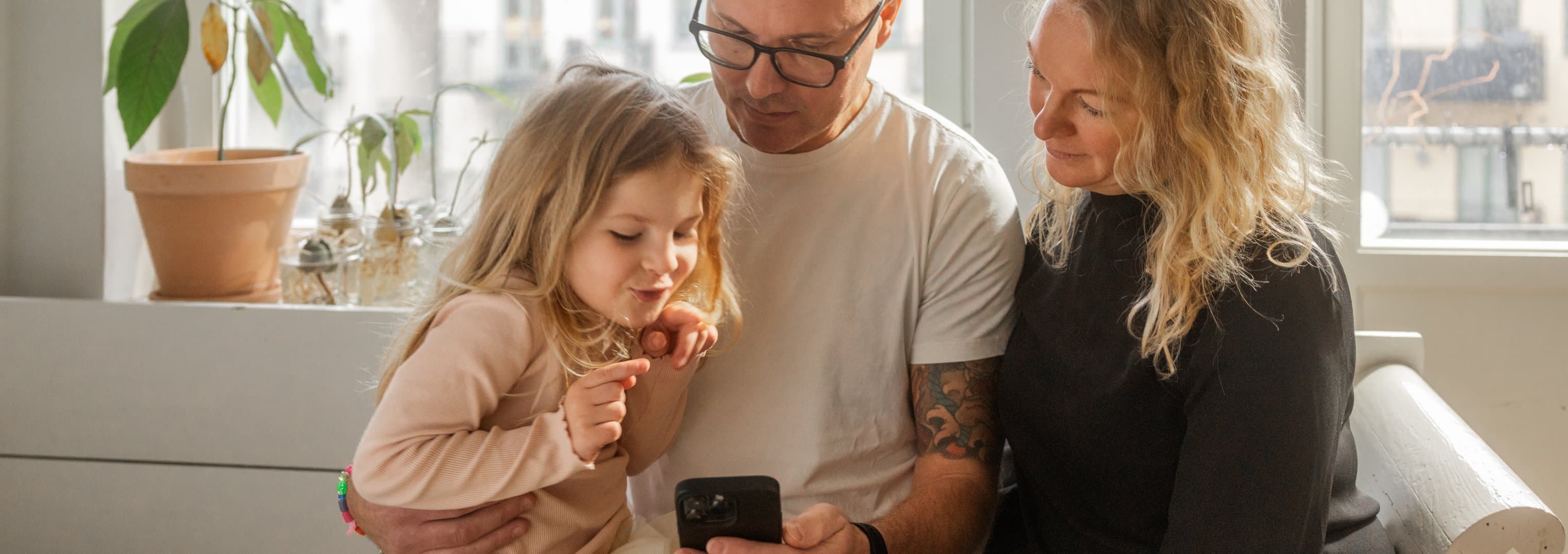 Familj sitter med telefon Familj sitter med telefon