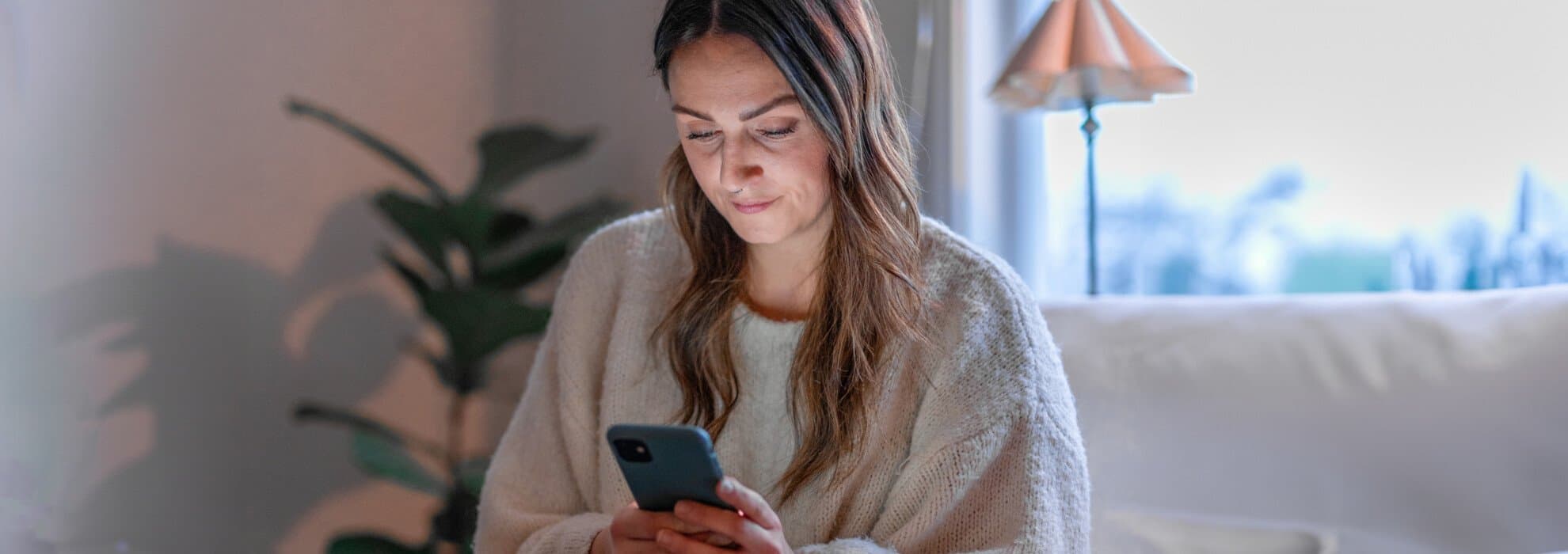 Kvinna som kollar i mobiltelefon Kvinna som kollar i mobiltelefon