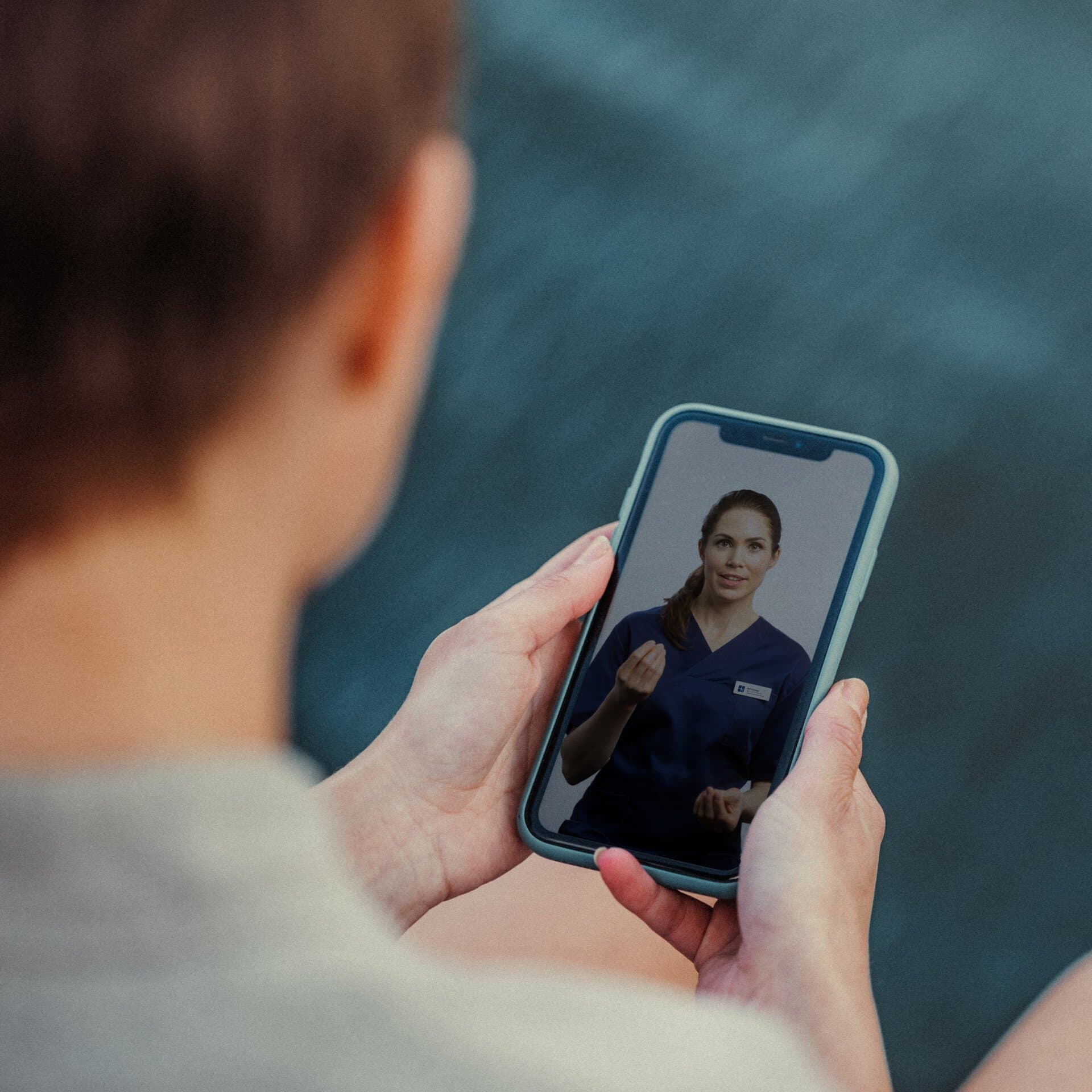 person håller i mobil och kollar i appen